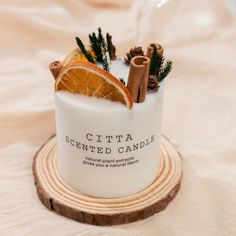 a candle with cinnamons and orange slices on it