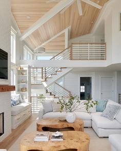 a living room filled with white furniture and a fire place in front of a flat screen tv