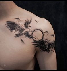 a man's chest with an eagle tattoo on his left shoulder and wings flying around it