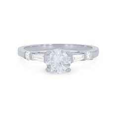 a white gold engagement ring with two baguets on the band and a round diamond center