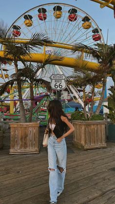 a woman standing in front of a ferris wheel