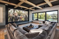 a living room with couches and a large screen on the wall