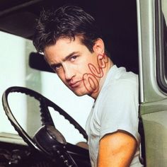 a man sitting in the driver's seat of a truck with his face painted