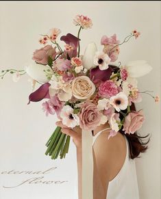 a woman holding a bouquet of flowers in front of her face with the word love on it