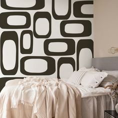 a bed sitting under a black and white wall