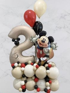 a mickey mouse balloon sculpture with balloons in the shape of numbers 2, 3 and 5