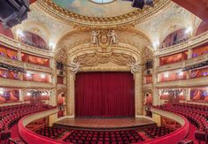 an empty auditorium with red curtains and seats