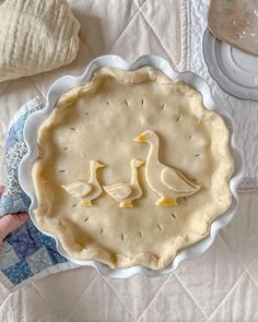 two ducks are sitting on top of a pie crust in the shape of a heart