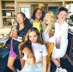 a group of young women standing next to each other in front of a kitchen counter