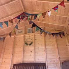 the inside of a building with wooden walls and flags hanging from it's ceiling