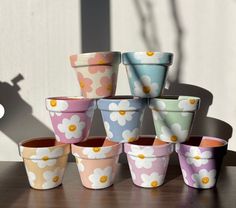 a group of flower pots sitting next to each other on top of a wooden table