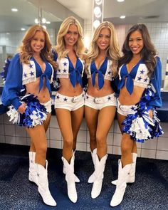 three cheerleaders are posing in the bathroom