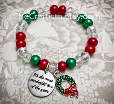 "✿ Beautiful Christmas bracelet in an easy to wear strong stretchy cord. Simply elegant! ✿ Strung within 8 mm smooth glass pearl beads, the focal point of this piece is an elegant and meaningful Wreath charm accompanied by a disc charm engraved with the words \"It's the most wonderful time of the year.\" ✿ This item comes in a dainty sheer organza drawstring pouch, ready for gift-giving. Average sizes: Petite/ slim: 6.5\" Standard adult: 7 Large adult: 7.5\" XL adult: 8\" TAGS: Christmas Bracele Christmas Jewerly, Christmas Jewelry Diy, Beaded Diy, Flower Girl Necklace, Christmas Bling, Holiday Beading, Sweet 16 Gifts, Jewerly Beads, Bracelet Pearl