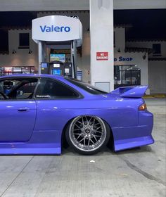 a purple car parked in front of a gas station with the word valero on it