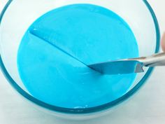 a person is cutting into something blue in a bowl