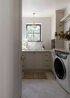 a washer and dryer in a small room with a window on the wall