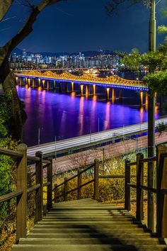 stairs leading up to the top of a hill with a bridge in the background