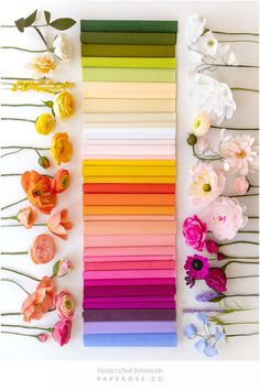 the colors of paper are arranged on top of each other, with flowers and leaves