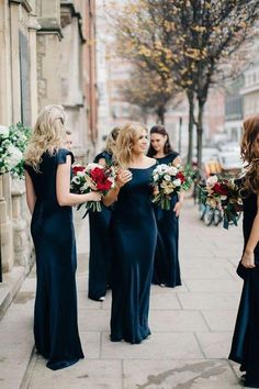 the bridesmaids are walking down the street with their bouquets in hand and looking at each other