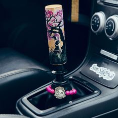 the steering wheel knob is decorated with pink beads