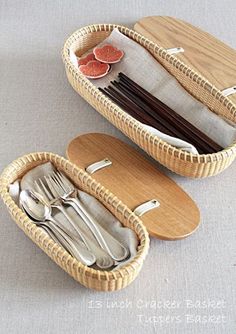 two baskets with forks and spoons in them sitting on a table next to each other