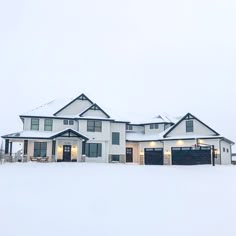 a large white house covered in snow with lots of windows on the front and side