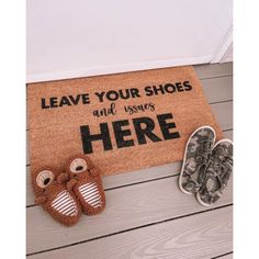 two pairs of shoes sitting on the floor next to a door mat that says leave your shoes and converses here