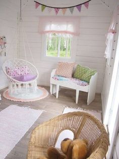 a small child's room with white walls and wood flooring, including a hammock bed