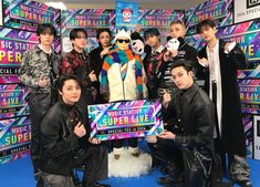 the group is posing for a photo in front of a stuffed animal and some signs