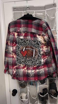 a plaid jacket hanging on a door with shoes in the bottom drawer and an image of a football