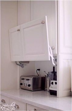 a kitchen with white cabinets and appliances on the counter