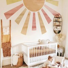 a baby's room with sunburst painted on the wall and crib