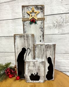 the nativity scene is displayed in front of a wooden sign and other decorations on a table