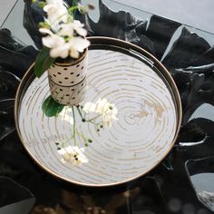 a vase with flowers is sitting on a glass table