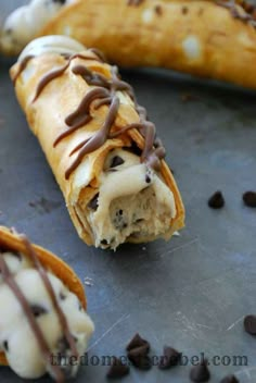 two chocolate chip banana split sandwiches on a baking sheet with one broken in half and the other partially eaten