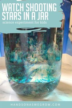 a glass jar filled with blue liquid on top of a table