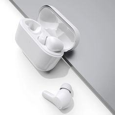 an airpods sitting on top of a table next to another earpiece in its case