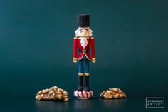 a nutcracker is standing next to some walnuts