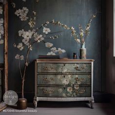 an old dresser with flowers on it in front of a wall