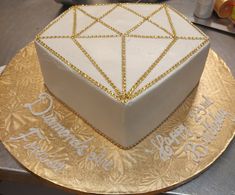 a white and gold birthday cake on top of a table