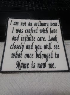 a piece of cloth with words written on it sitting next to a laptop computer keyboard