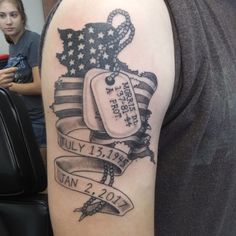 a man with a tattoo on his arm has an american flag and dog tags attached to it