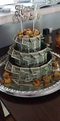 a birthday cake made out of money sitting on top of a table