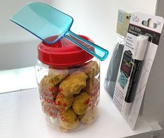 a glass jar filled with dog food next to a package of toothbrushes