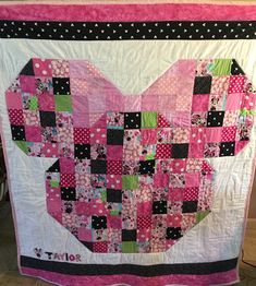 a heart shaped quilt hanging on the wall