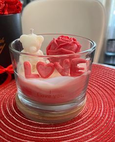 a glass bowl filled with love on top of a table