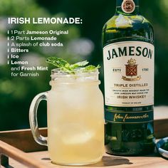 a bottle of jameson next to a glass filled with lemonade and garnish