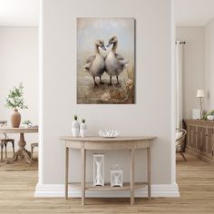 two birds standing next to each other on a table in front of a white wall