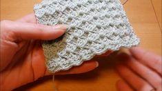 someone is crocheting the stitchs together to make a square ornament