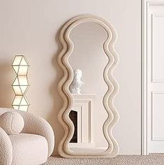 a large white mirror sitting on top of a floor next to a chair and lamp